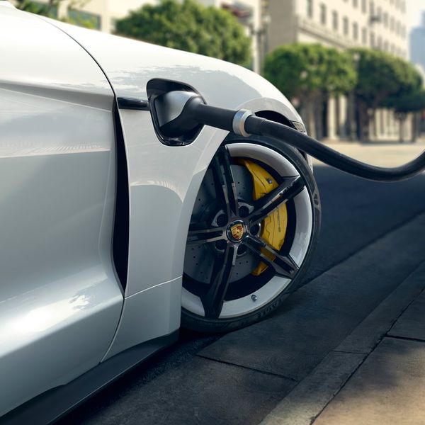 White Porsche Taycan charging cable and rim/yellow brake detail